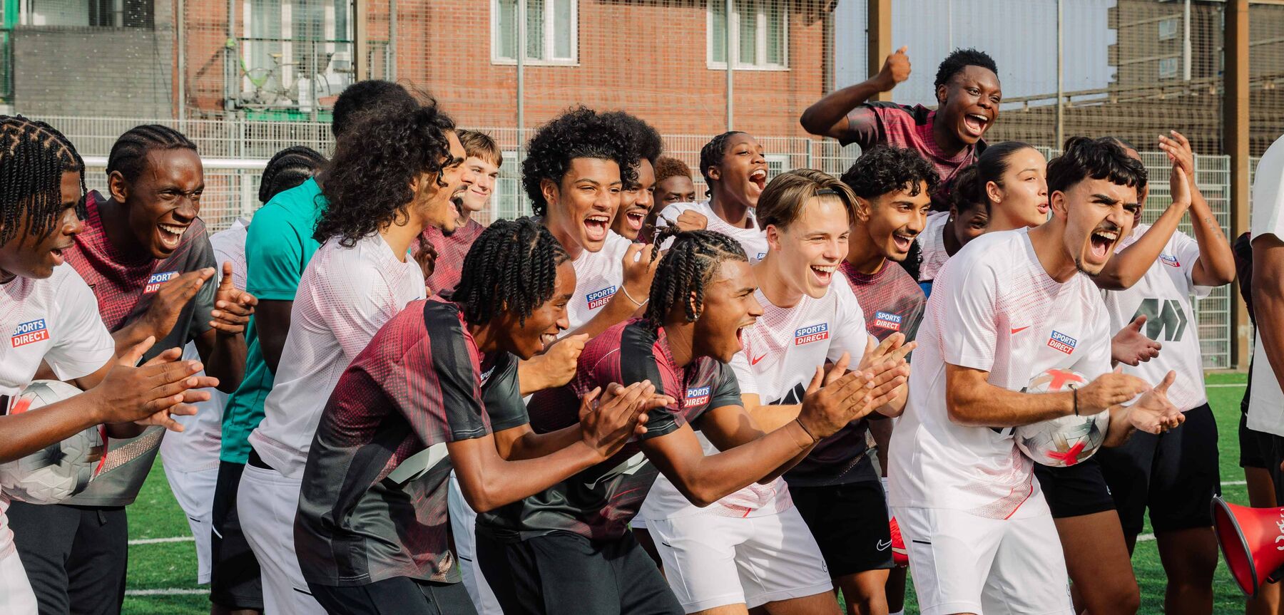 Players celebrating together on a grassroots pitch